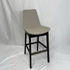 Beige leather counter stool with Eiffel silhouette, black wood legs, and brass footrest.