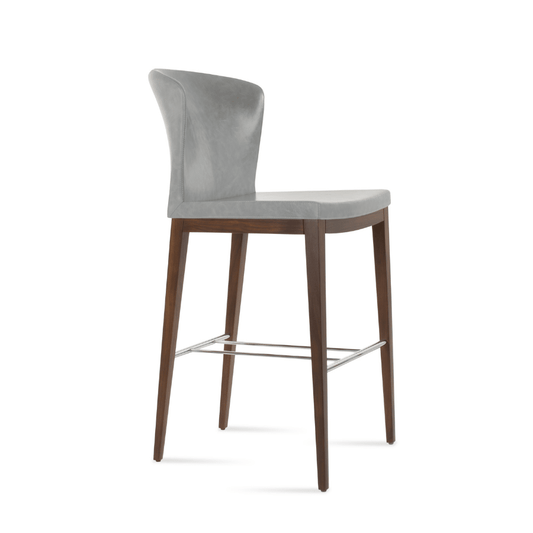 Grey upholstered counter height stool with winged back and dark wood legs